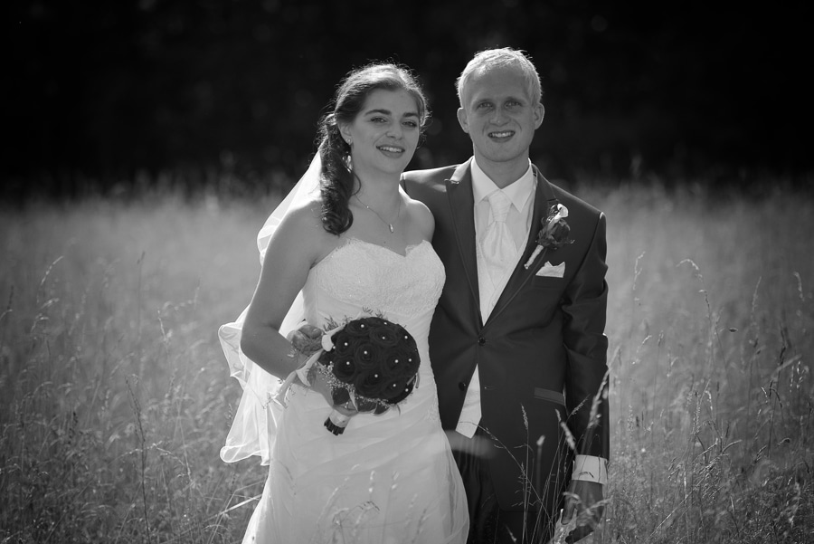 after wedding shooting bei langenburg - sichtbare momente - brautpaar steht in einer wiese - schwarzweiss aufnahme-