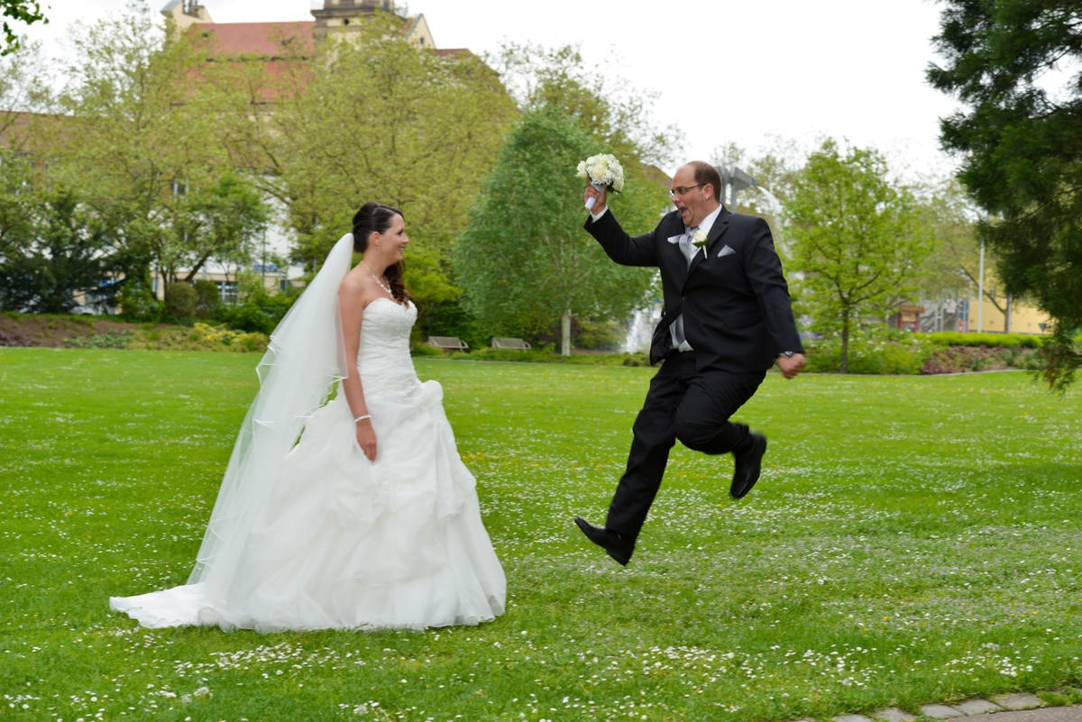 hochzeitsbilder - sichtbare momente - bräutigam bringt mit einem sprung den strauss zur braut